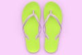 Beach green flip-flops or sandals isolated on pink background.