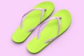 Beach green flip-flops or sandals isolated on pink background.
