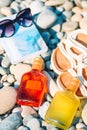 Beach hat on opened book with sunscreen and shoes on pebble beach