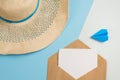 Beach hat, postcard in the envelope and the plane on a blue background. concept of flight on vacation and travel Royalty Free Stock Photo