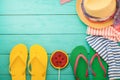 Beach holidays. Flip flops, watermelon candy, hat, towels. Summer accessories and copy space on blue wooden background. Top view Royalty Free Stock Photo