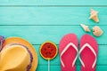 Beach holidays. Pink flip flops, summer hat with candy and copy space on blue wooden background. Top view. Mock up Royalty Free Stock Photo