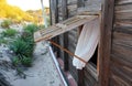 Beach house, wooden windows opened, sandy path leading to sea in background. Tropical island beach resort Royalty Free Stock Photo