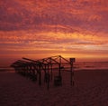 Beach hut frames silhouetted against vivid red sunset sky Royalty Free Stock Photo