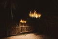 Beach hut in the night. Straw lamp in village backyard. Eco hotel in Africa. Outdoor lantern in darkness in tourist resort. Royalty Free Stock Photo