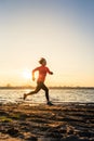 Beach jogging at sunrise, lake coastline