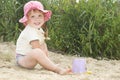 The beach at the lake in the sand a little girl in a hat playin Royalty Free Stock Photo