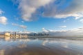 Beach landscape with buildings mountains and cloudy blue sky