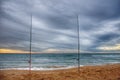 Beach landscape photography on cloudy day with two fishing rods, surfcasting style.