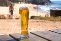 Beach leisure with beer in outside bar and ocean view. Sunny coastline and one beer glass for tourist. Vacation concept