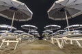 Beach and lido at night with umbrellas and deck chairs Royalty Free Stock Photo