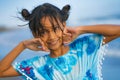 Beach lifestyle portrait of young beautiful and happy Asian child girl 8 or 9 years old with cute double buns hair style playing Royalty Free Stock Photo