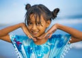 Beach lifestyle portrait of young beautiful and happy Asian child girl 8 or 9 years old with cute double buns hair style playing Royalty Free Stock Photo