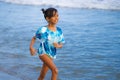 Beach lifestyle portrait of young beautiful and happy Asian child girl 8 or 9 years old with cute double buns hair style playing Royalty Free Stock Photo