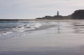 A beach and a lighthouse in the distance at Waipapa Point in the Catlins in the South Island in New Zealand