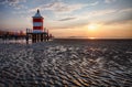 Beach with lighthouse in Italy resort Lignano at sunrise