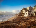 A beach with a lot of debris and a house that is in ruins Royalty Free Stock Photo