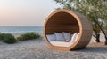 Beach lounge bed with a canopy sits invitingly on the sandy shore, surrounded by greenery, as the sun sets Royalty Free Stock Photo