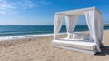 Beach lounge bed with a canopy sits invitingly on the sandy shore, surrounded by greenery, as the sun sets Royalty Free Stock Photo