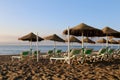 Beach lounge chair and beach umbrella at lonely sandy beach. Costa del Sol (Coast of the Sun), Malaga in Andalusia, Spain Royalty Free Stock Photo