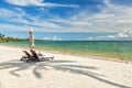 Beach Lounge Chairs under palm tree leaves at the shore of India Royalty Free Stock Photo