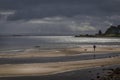 Beach and man in sunlight at whiting bay on arran