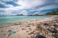 beach with microplastics and garbage floating in the water
