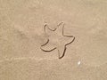 Beach. Natural background. Print on the wet sand from a children`s toy in the shape of a starfish Royalty Free Stock Photo