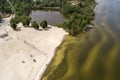 A beach near the city in springtime. Aerial view. Dirty river or lake. Few people. Quarantine