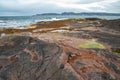 Beach on the northern ocean is made of stones covered with colorful moss. Teriberka, Barents Sea, Murmansk region, Kola Peninsula Royalty Free Stock Photo