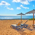 Beach with parasol and chaise longues