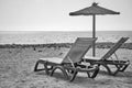 Beach with parasol and chaise longues