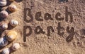 Beach party text drawn on a sand