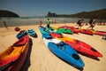 Beach on Phi Phi Island with lots of colorful boats and men with backpacks