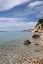 Picturesque bay on the Croatian seaside, expressive blue sky with white clouds and calm clear sea water on a cloudy summer morning Royalty Free Stock Photo