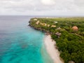 Beach and Pier at playa Kalki in Curacao, tropical beach from the sky drone view at beach with palm tree