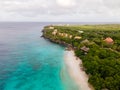 Beach and Pier at playa Kalki in Curacao, tropical beach from the sky drone view at beach with palm tree