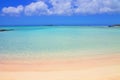 Beach with pink sand and turquoise water and clouds in blue sky. Royalty Free Stock Photo