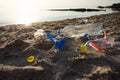 Plastic Litter Lying On Sand Near Sea Polluting Seashore Background Royalty Free Stock Photo