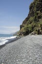 Beach Ponta de Sol pebble beach and rocky green coastline with cliffs, Madeira island
