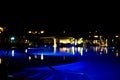 Silhouetted blue water pool at night on tropical resort