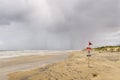 Beach red flag danger swimming sign in a cloudy day Royalty Free Stock Photo