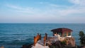 A beach with a red house on a cliff overlooking the ocean Royalty Free Stock Photo