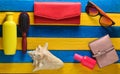 Beach resort concept. Female beach accessories on blue yellow wooden background. Shell, glasses, purse, sunblock, comb, perfume Royalty Free Stock Photo