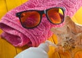 Beach resort concept. Female beach accessories on a blue yellow wooden background. Shell, glasses, towel, sunblock Royalty Free Stock Photo