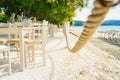 Beach restaurant with all white colored furniture in front of the white turquoise colors of the sand and sea. Bright sunny day. Royalty Free Stock Photo