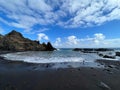 Beach and rocks with black volcanic sand and ocean waves. Royalty Free Stock Photo