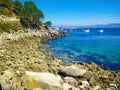 Beach of rocks in Cies Islands, Galicia, Spain, with boats diving in front of it Royalty Free Stock Photo