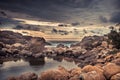 Beach rocks lagoon tropical landscape with palm trees and round stones with dramatic sunset sky vibrant colors in Sri Lanka Royalty Free Stock Photo