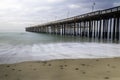 Beach with rocks and pier, Ventura California. Green ocean, blue sky, clouds. Royalty Free Stock Photo